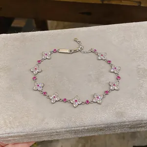 Detailansicht eines silbernen Blumenarmbands mit rosa und klaren Zirkon-Akzenten.