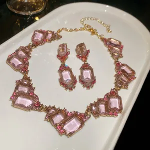 Detailed macro view of pink geometric gemstone necklace and earring set in retro palace style