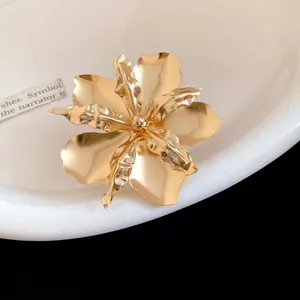 Detail shot of a large vintage-style gold metallic flower ring with a glossy polished finish