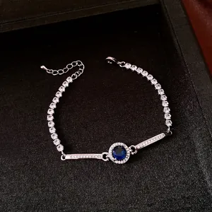 Elegante bracciale argentato con zircone blu tondo e cristalli chiari scintillanti in box