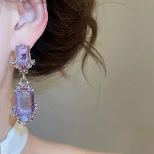 Detail of vintage purple crystal geometric earrings with intricate court style design
