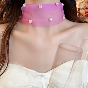 Primo piano di un girocollo in rete viola decorato con delle eleganti perle bianche.