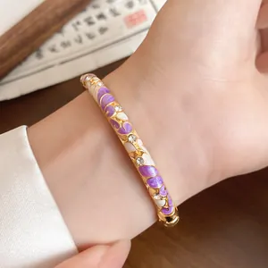 Close-up of vintage gold-plated bracelet with purple enamel flowers and crystals