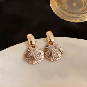 Elegant French style gold-plated stud earrings with a detailed radial leaf texture