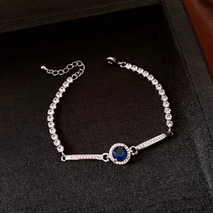 Dettaglio di un bracciale vintage con pietra blu tonda e decorazioni scintillanti in zircone