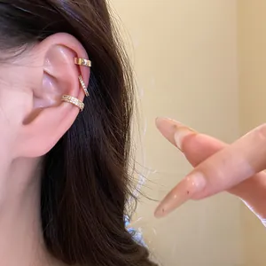 Detail shot of a gold-plated ear cuff set with sparkling zircons on a model's ear