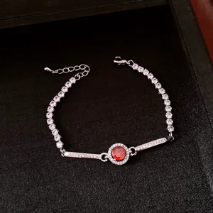 Dettaglio ravvicinato di un bracciale vintage argento con zircone rosso rotondo.