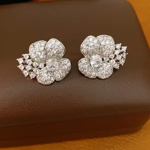 Close-up of silver-toned flower stud earrings paved with sparkling cubic zirconia stones.