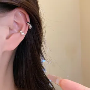 Close-up view of minimalist silver non-piercing ear cuffs with pearl and zircon accents