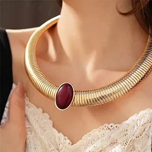 Collana rigida dorata a costine con elemento centrale ovale in resina bordeaux