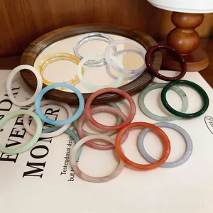 Gros plan de joncs en résine colorés avec des motifs style lavis sur un fond chaud