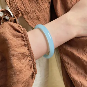 Gros plan d'un élégant bracelet jonc en calcédoine bleu clair translucide sur un poignet