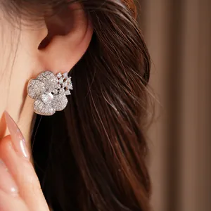 Close-up detailed view of silver zircon flower stud earrings on model showing elegant sparkle