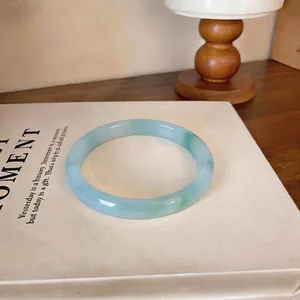 Vue rapprochée montrant la texture translucide et les motifs d'encre verte du bracelet
