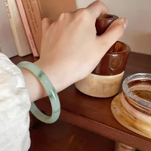 Gros plan d'un jonc en calcédoine translucide avec des motifs de lavis vert naturel.