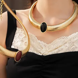 Dettaglio collana a girocollo dorata con grande pietra ovale in resina nera