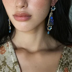 Detailed view of vintage palace style earrings with blue resin flowers and rhinestones