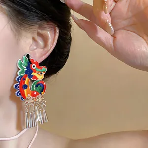 Detailed macro view of vibrant embroidered dragon earrings with metallic tassels in ethnic style.