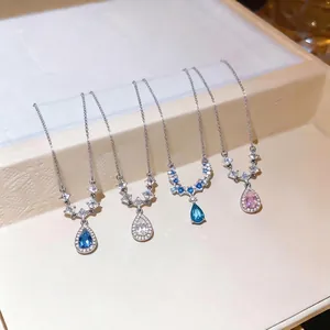 Elegante set di quattro collane di cristallo con pendenti a goccia blu e rosa pallido