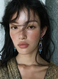 Macro view of vintage palace style floral earrings with blue accents on a fashion model