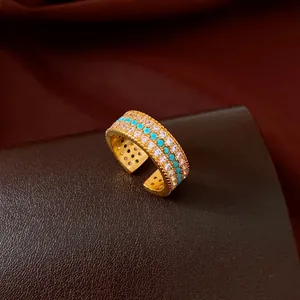 Detailed view of a vintage gold-plated ring with turquoise beads and sparkling cubic zirconia.