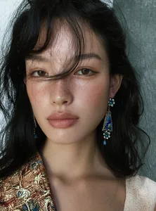 Close-up detail of vintage court style resin flower drop earrings with crystals on Asian model