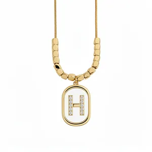 Elegant gold-plated oval pendant necklace featuring a sparkling rhinestone H initial detail