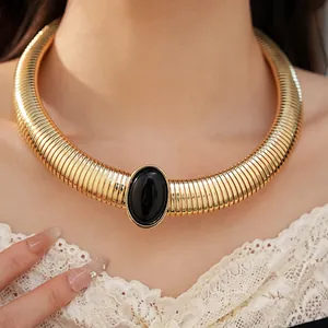 Dettaglio della collana girocollo dorata a costine con pietra ovale in resina nera