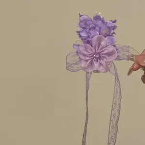 Detailed view of a purple chiffon flower hair clip featuring elegant long lace ribbon streamers