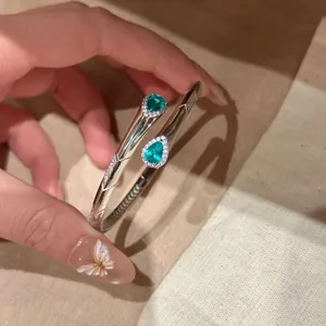 Dettaglio di un elegante bracciale argento con pietre verdi a goccia d'acqua