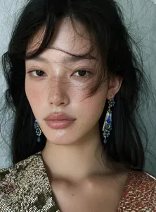 Close-up of vintage resin floral earrings with blue palace style design on model.