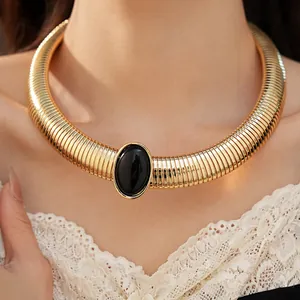 Vista dettagliata di una collana a colletto dorata a coste con pietra ovale in resina nera