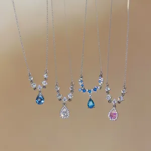 Dettaglio di quattro pendenti in cristallo colorato a forma di pera su catene d'argento