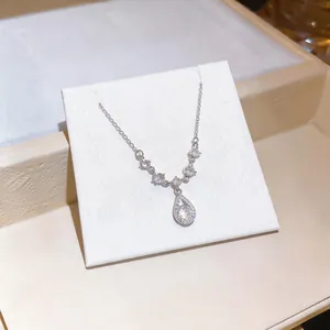 Primo piano di una collana con ciondolo a goccia in cristallo su carta display.