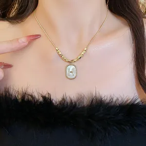 Detailed view of an elegant gold necklace featuring a zircon-studded H letter pendant.