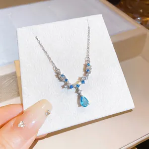 Primo piano della collana con ciondolo in cristallo blu a goccia e catena d'argento.