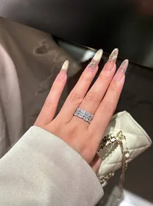 Elegant detail showing a sparkling cubic zirconia wide band ring on a manicured hand