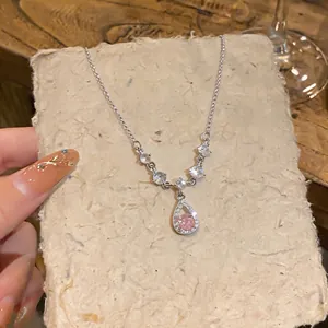 Dettaglio di una collana in argento con ciondolo in cristallo rosa su carta testurizzata