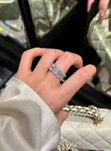 Detailed view of an elegant silver-toned zircon ring worn on a finger for a luxury look.