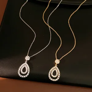 Dettaglio di eleganti collane a goccia in oro e argento con ciondoli in zirconia