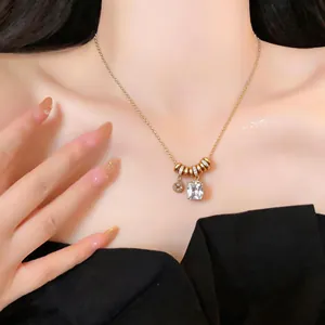 Détail d'un collier doré élégant avec un pendentif en cristal rectangulaire scintillant