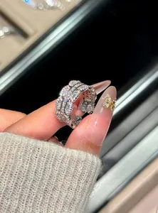 Close-up of sparkling multi-row zircon ring held between fingers showing fine details