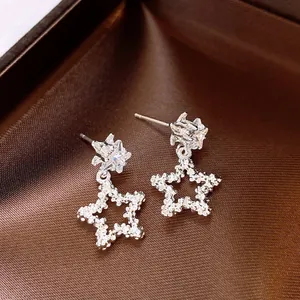 Gros plan détaillé de boucles d'oreilles étoiles avec un pendentif plissé argenté chic