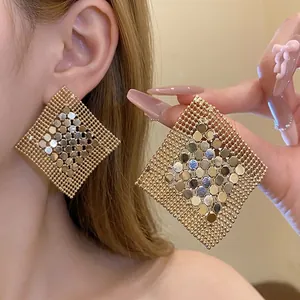 Statement oversized geometric gold sequin square drop earrings with beaded edge on Asian model