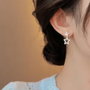 Gros plan de boucles d'oreilles étoiles avec zircone portées par un mannequin asiatique