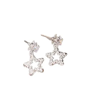 Boucles d'oreilles étoiles en argent avec pendentif plissé et zircons sur fond blanc