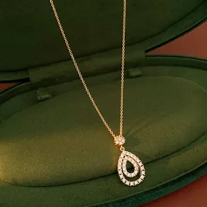 Dettaglio squisito di una collana a goccia con zirconi in una scatola di velluto verde scuro
