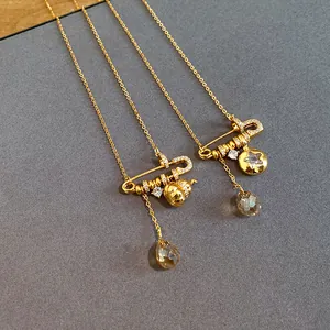 Detailed view of luxury gold-plated necklaces with gourd, star and teardrop pendants