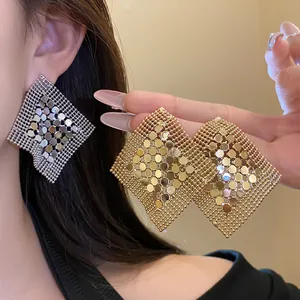 Detailed view of geometric metal sequin mesh earrings in gold and silver finish.