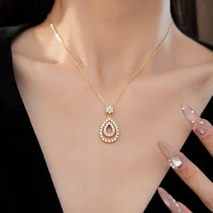 Primo piano di un'elegante collana con pendente a goccia e zirconi scintillanti sul modello.